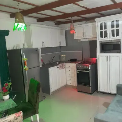 a kitchen with white cabinets and a stove top oven at Tropical 2 in La Hondonada