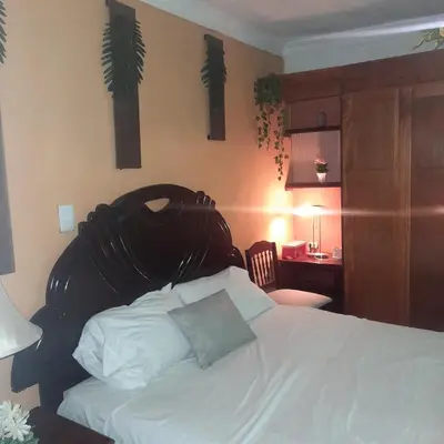 a bedroom with a bed with a black headboard and a desk at Tropical 2 in La Hondonada