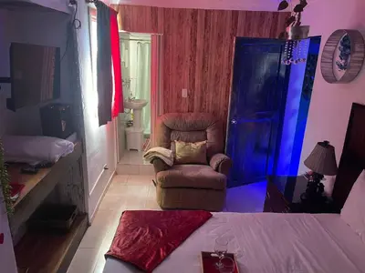 a room with a bed and a chair and a room with a bed at Tropical 2 in La Hondonada