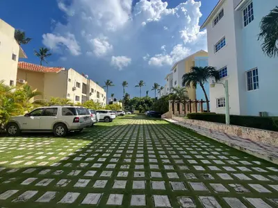 a cobblestone street with parked cars and buildings at Luxury Beach Penthouse with Pool, BBQ, AC, Wi-Fi, 5-Min Walk to El Cortecito & Bavaro Beaches, Punta Cana in Punta Cana