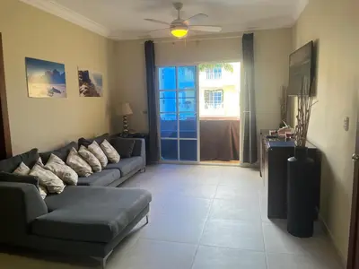 a living room with a couch and a table at Luxury Beach Penthouse with Pool, BBQ, AC, Wi-Fi, 5-Min Walk to El Cortecito & Bavaro Beaches, Punta Cana in Punta Cana