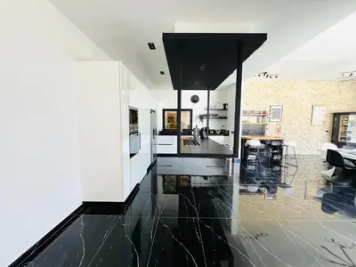 a kitchen with black and white appliances and a living room at Casa B&W, Villa luxueuse Exceptionnelle, 8 personnes, à 1 min de la plage in Las Galeras
