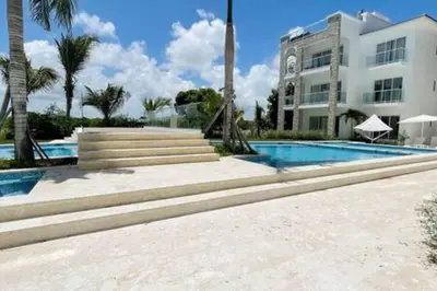 a swimming pool in front of a building at Brand New beach and golf condo in Punta Cana in Punta Cana