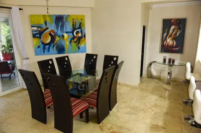 a dining room with a glass table and chairs at Hispaniola Luxury Ocean Front Condo in Sosúa