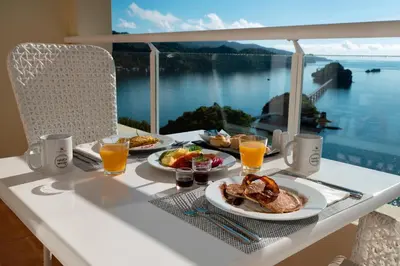 a table with plates of food and a view of the water at Eurostars Grand Cayacoa in Santa Bárbara de Samaná