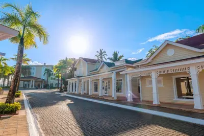 a row of houses on a street with a palm tree at Eurostars Grand Cayacoa in Santa Bárbara de Samaná