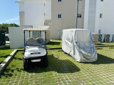 a golf cart with a cover on the grass at Peaceful haven overlooking the golf course in Punta Cana