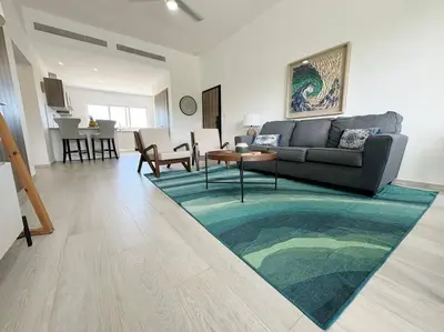 a living room with a couch and a rug at Peaceful haven overlooking the golf course in Punta Cana
