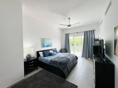 a bedroom with a bed and a television and a window at Peaceful haven overlooking the golf course in Punta Cana
