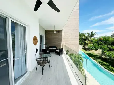 a balcony with a table and chairs and a pool at Peaceful haven overlooking the golf course in Punta Cana