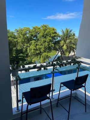 a balcony with two chairs and a view of the ocean at Tiny Home-El Pueblito in San Felipe de Puerto Plata