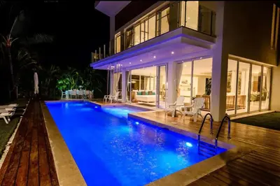 a swimming pool in front of a house at night at New private luxury villa in Punta Cana in Punta Cana