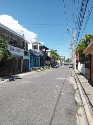 an empty street in a town with a car driving down the street at Acogedor apartamento entero in Mandinga