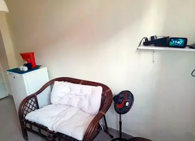 a wicker chair sitting in a room with a fan at Acogedor apartamento entero in Mandinga