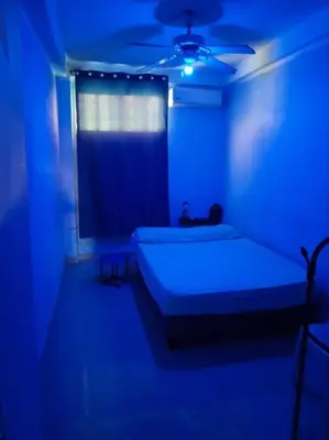 a blue room with two beds and a window at Confortable apartaestudio en Santo Domingo Este in Santo Domingo