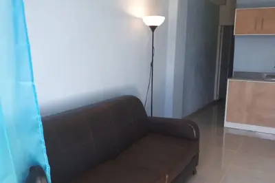 a living room with a brown couch and a lamp at Confortable apartaestudio en Santo Domingo Este in Santo Domingo