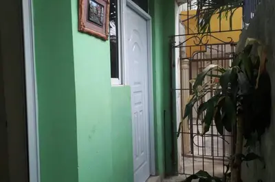 a door to a house with a green wall at Confortable apartaestudio en Santo Domingo Este in Santo Domingo