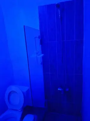 a bathroom with a toilet and a shower with blue lights at Confortable apartaestudio en Santo Domingo Este in Santo Domingo