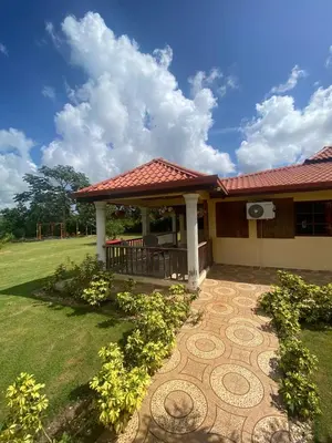 a house with a tile roof and a patio at Villa las Rosas JP in Bayaguana
