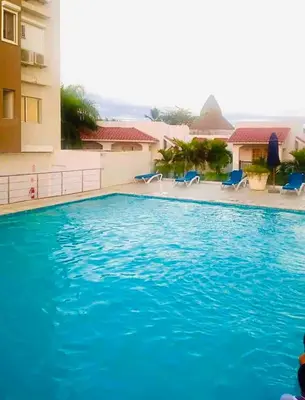 a large blue swimming pool next to a building at Boca chica Apartment Near the bech in Boca Chica
