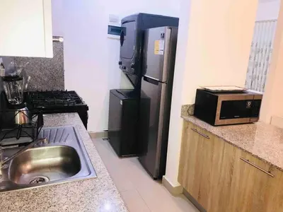 a small kitchen with a refrigerator and a microwave at Boca chica Apartment Near the bech in Boca Chica
