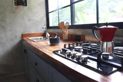 a kitchen counter with a stove top with a tea kettle at Villa Cantares del Rio in La Cuaba