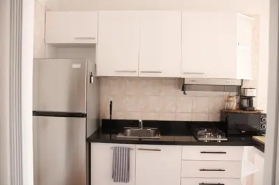 a kitchen with white cabinets and a stainless steel refrigerator at Albatros by R&R 2 in Villas del Mar