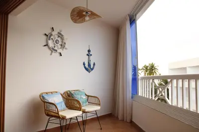 a balcony with two chairs and a clock on the wall at Albatros by R&R 2 in Villas del Mar