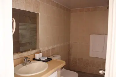 a bathroom with a sink and a toilet and a mirror at Albatros by R&R 2 in Villas del Mar