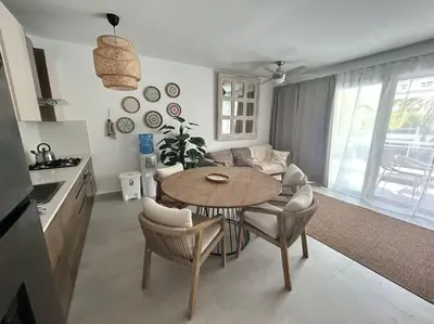 a kitchen and living room with a table and a couch at Słoneczny apartament AC WiFi in La Laguna