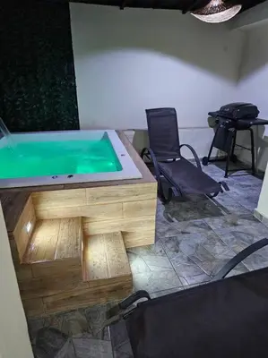 a jacuzzi tub in a room with two chairs at vista a toda la ciudad y montaña in San Felipe de Puerto Plata