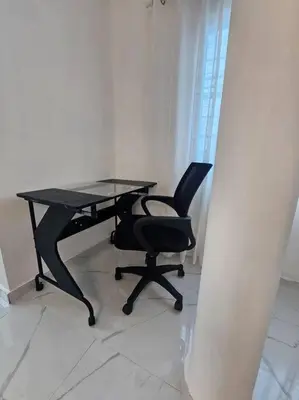 a black desk and a chair in a room at vista a toda la ciudad y montaña in San Felipe de Puerto Plata