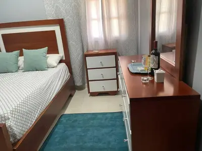 a bedroom with a bed and a desk with a bottle of wine at apartamento 3 habitaciones 15 minutos aeropuerto las america in San Isidro