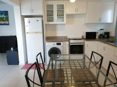 a kitchen with a glass table and chairs in it at Rincón de Tranquilidad in Bayahibe