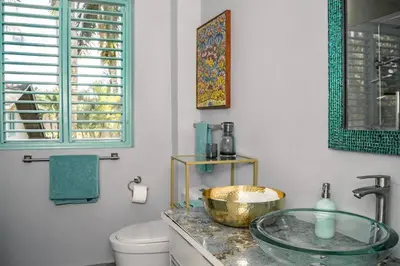 a bathroom with a glass sink and a toilet at Renovated Condo at the Beach Close to Everything in Las Terrenas