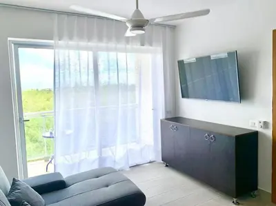 a living room with a couch and a large window at Vibe Gorgeous one bedroom apartment view beach in La Laguna