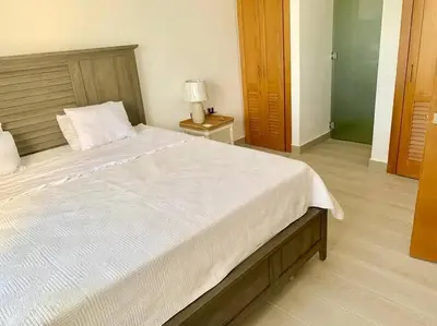 a bedroom with a large bed and a lamp on a table at Gorgeous 2 bedroom apartment in Vibe Residence in Bayahibe