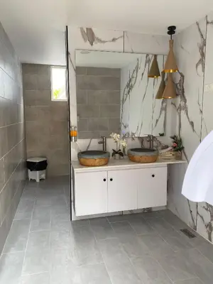 a bathroom with two sinks and a large mirror at Sun on the bay beach hotel in Palmar de Ocoa