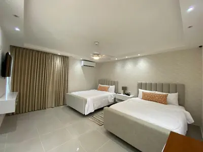 a hotel room with two beds and a television at Sun on the bay beach hotel in Palmar de Ocoa