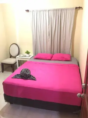 a bedroom with a pink bed with a window at Confortable Apto de relajación in Los Paredones
