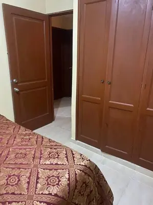 a bedroom with a bed and some wooden cabinets at Confortable Apto de relajación in Los Paredones