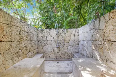 a stone wall with two benches in front of it at Casa de Campo villa – Luxurious villa up to 12 people with pool jacuzzi golf in La Romana