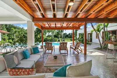 a patio with a couch and chairs and a table at Casa de Campo villa – Luxurious villa up to 12 people with pool jacuzzi golf in La Romana