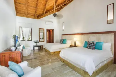 a bedroom with two beds and a couch at Casa de Campo villa – Luxurious villa up to 12 people with pool jacuzzi golf in La Romana