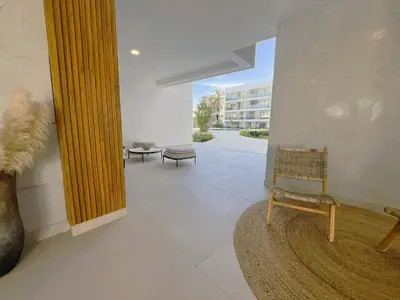 a living room with a chair and a mirror at Sausalito | Relax Vista Piscina in Punta Cana