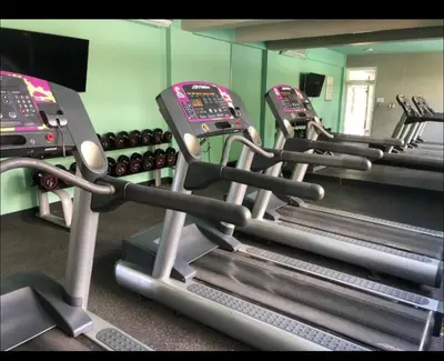 a row of treadmills in a gym at Residencial Mediterraneo in Santiago de los Caballeros