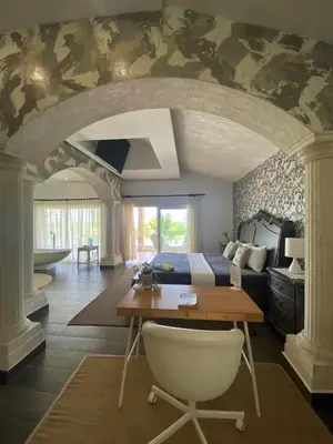 a bedroom with a bed and a desk with a chair at Villa Ruben Juan Dolio in Juan Dolio