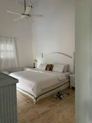 a white bedroom with a bed and a ceiling fan at VILLA EN CASA DE CAMPO, La Romana, Rep Dom in La Romana