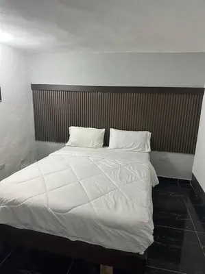 a bed with white sheets and pillows in a room at VILLA EN CASA DE CAMPO, La Romana, Rep Dom in La Romana