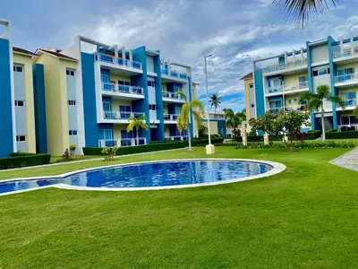 a large apartment building with a swimming pool in front of it at Apartamento tipo hotel WIFI - Estacionamiento in Punta Cana